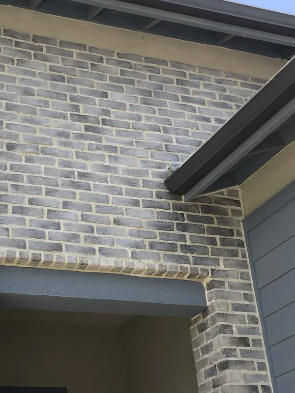 Thin brick veneer clads a two-storey entry, with a soldier-course header spanning the opening.