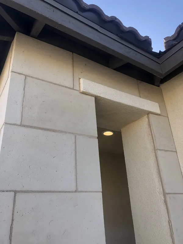 Limestone veneer corner column rises to meet the clay tile roofline.
