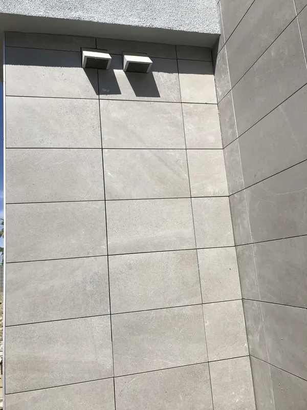 Large-format grey tile panels wrapping a clean exterior corner.